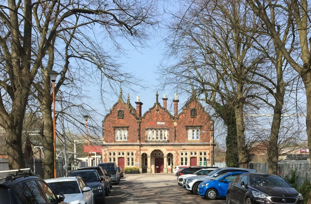 Photo of Stone Station, a red brick building with cars parked in front.